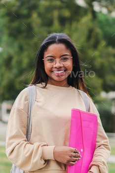 Vertical individual portrait of a happy hispanic smart school girl with glasses smiling and laughing