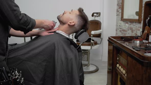 Young Hipster Caucasian Man During Beard Grooming in Modern Barber Shop