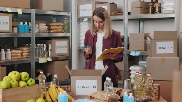 Young Woman with Clipboard Volunteering at Food Bank