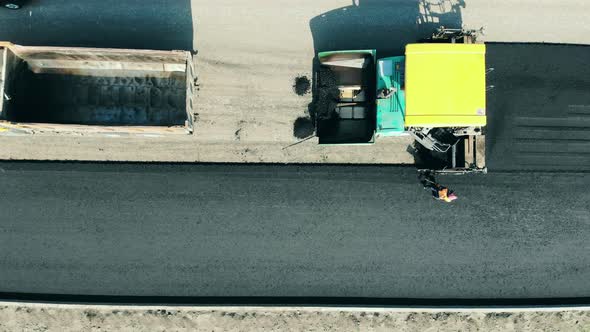 Road-manufacturing Machines and Workers in a Top View