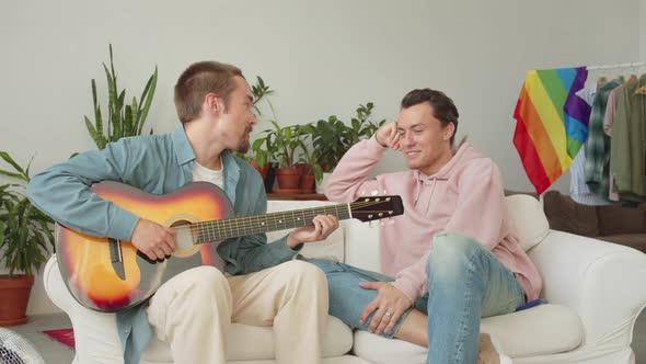 One of Lgbt Men is Playing Guitar and Singing Songs for His Boyfriend and Another is Sitting and