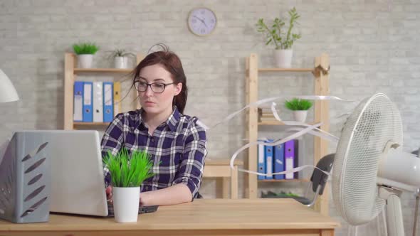 Young Woman Working at a Laptop Next To a Fan Escapes From the Heat Slow Mo