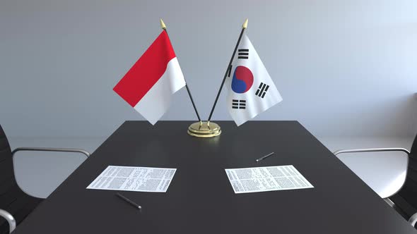 Flags of Indonesia and South Korea and Papers on the Table