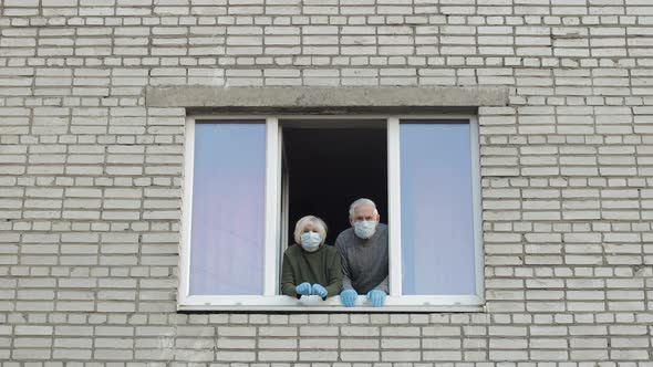 Old Grandparents Stay at Window Isolated at Home on Quarantine. Coronavirus