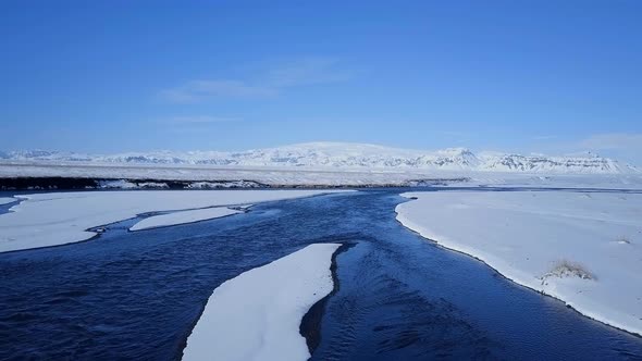 Aerial View of a Blue River in a Snowy Landscape