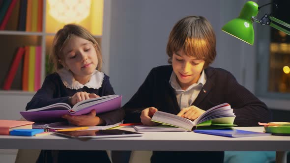 Two School Children Sitting at Desk at Literature Lesson