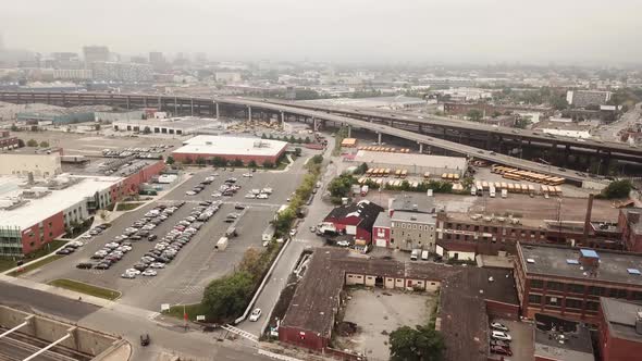 Cars Parked On The Parking Lot In Front Of A Building With A View Of Expressway On The Background In