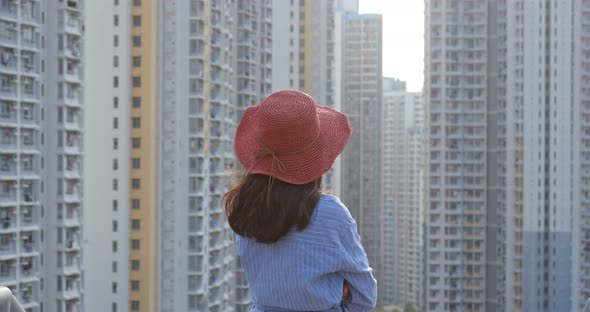 Woman wearing red straw hat and look around in the city