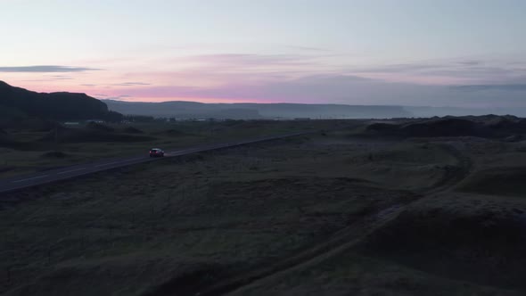 Car Moving on Road Through Evening Nordic Countryside