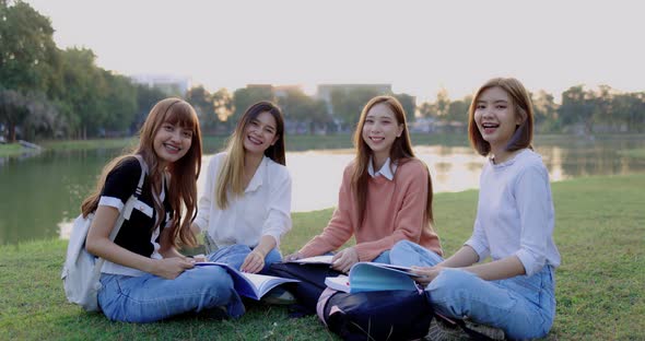 Group of Asian college student girl friends are sitting in the park together.