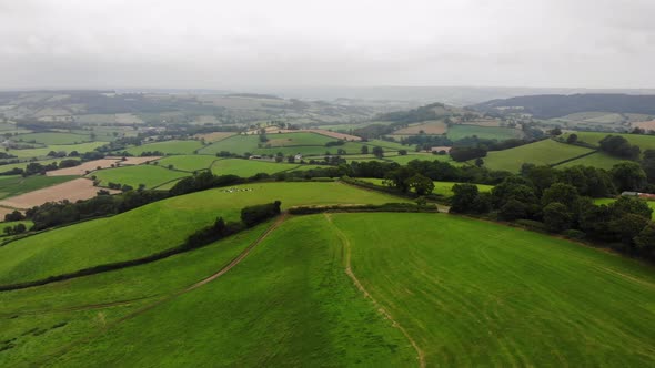 Aerial rising shot over the East Devon Countryside showing the valleys of the Blackdown Hills