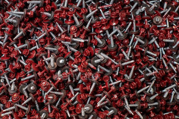 er and red hexagonal head, hardware background. Group of hex head silver screws for metalworking and construction work with fasteners