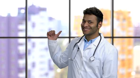 Young Darkskinned Hindu Doctor Spinning and Pointing Back with His Thumb