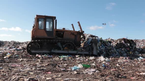 A Tractor That Collects Garbage In Pile At A Landfill