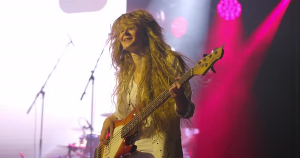 Woman Guitarist at a Rock Concert Plays Electric Guitar on the Open Stage