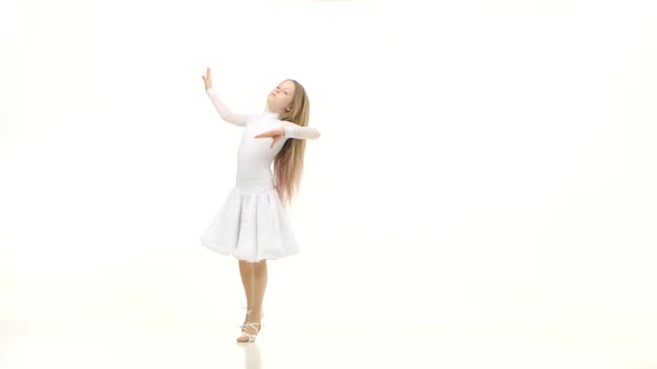 Child Dances in a Beautiful White Dress on a Parquet Floor. White Background