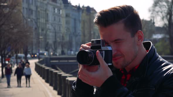 A Young Handsome Man Takes Photos with a Camera - Face Closeup - a Busy Street