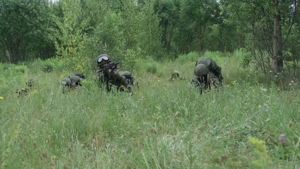 Soldiers in Camouflage with Assault Rifles Out of the Ambush in the Field Military Action in the