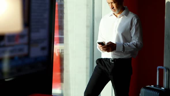 Businessman using mobile phone in hotel room