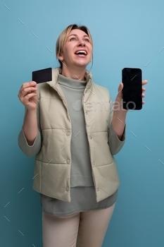 young 30s woman uses smartphone to work with money card