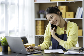 Entrepreneur of Asian woman using a laptop with box Cheerful success Asian women chatting on the pho