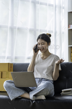 Entrepreneur of Asian woman using a laptop with box Cheerful success Asian women chatting on the pho