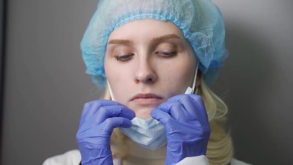 Sad Tired Female Doctor Nurse in Protective Suit or Costume Taking Off Mask and Glasses After Long