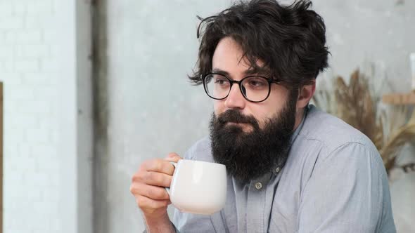 Handsome Bearded Man in the Kitchen Enjoy a Cup of Tea After a Hard Work Day