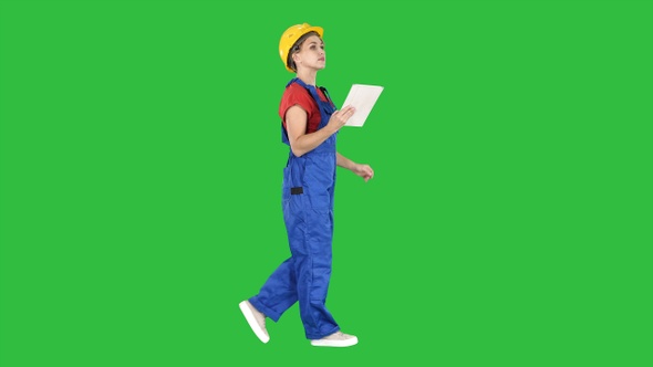 Construction lady using electronic tablet walking
