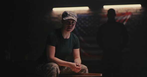 Female Soldier Sitting Near Anonymous Commander