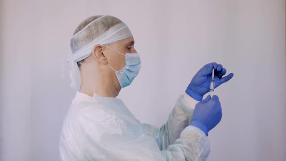 The Doctor Is a Surgeon, Holding a Syringe with the Vaccine. He Is Preparing To Give the Patient an