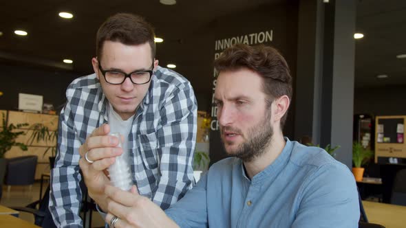 Male Colleagues Discussing Work of Mechanism Detail