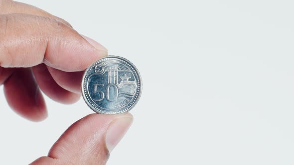 Fingers Hold A Singapore 50c Coin Back