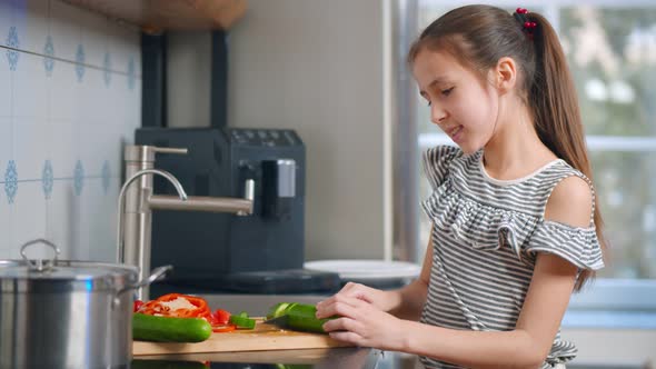 Cute Schoolgirl Cutting Vegetables Making Salad for Dinner