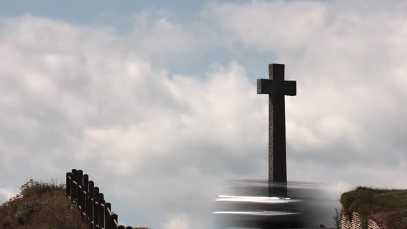 Zooming in timelapse of a village stone cross memorial with beautiful blue sky and cloudsing in the