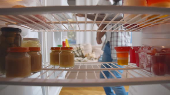 African Dad and Little Son in Kitchen Taking Jar of Baby Food in Fridge