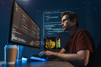 mputer at home office at night, working on software, coding new application, sitting in front of big pc monitor. Data science specialist at work