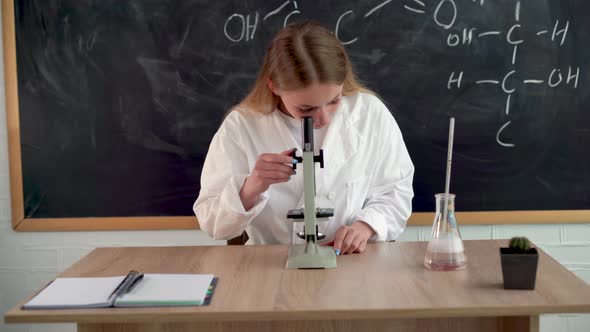 A Serious Girl Chemist Conducts Research in a College Classroom for Students Looking Through a