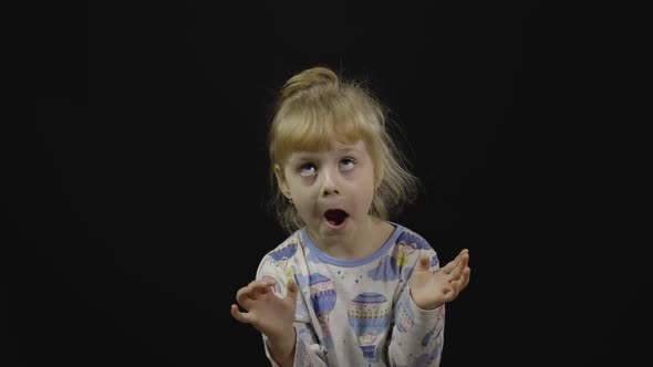 Little Girl in Pajama Is Dancing and Playing on Black Background. Happiness