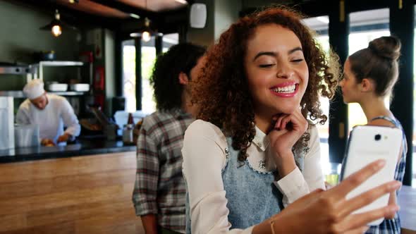 Smiling woman taking a selfie on mobile phone