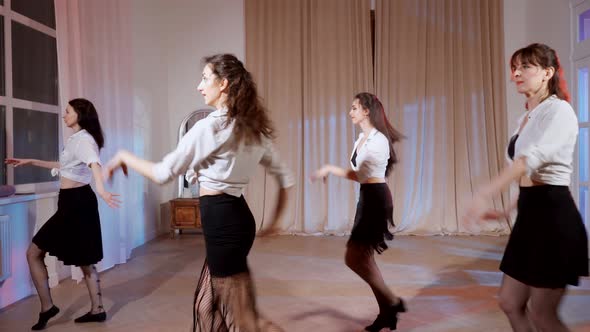 Four Girls in Black Skirts and White Shirts are Dancing Indoors