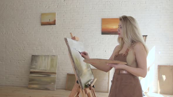 Girl Artist Paints on Canvas on Easel in Slow Motion