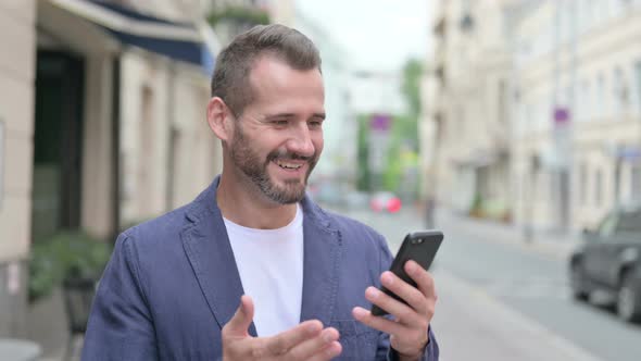 Mature Adult Man Celebrating on Smartphone