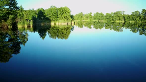 Aerial Video of the Lake on a Warm Summer Day in Light of the Setting Sun