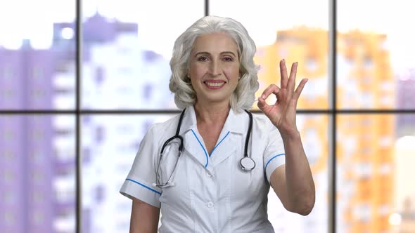 Old Senior Female Doctor Wearing Stethiscope and Showing Okay Gesture