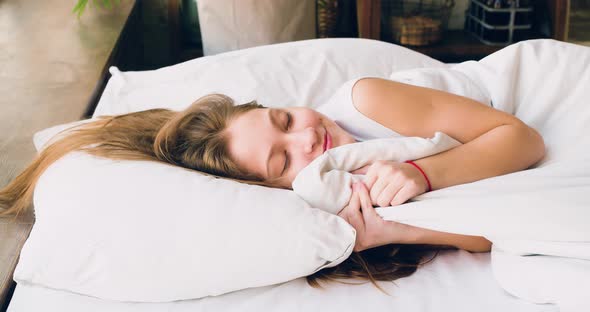 A Tenyearold Girl is Sleeping  She Straightens the Blanket and Lies Down More Comfortably