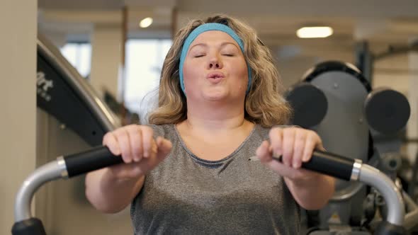 Woman Doing Fitness Exercises on Chest Press Machine at the Gym