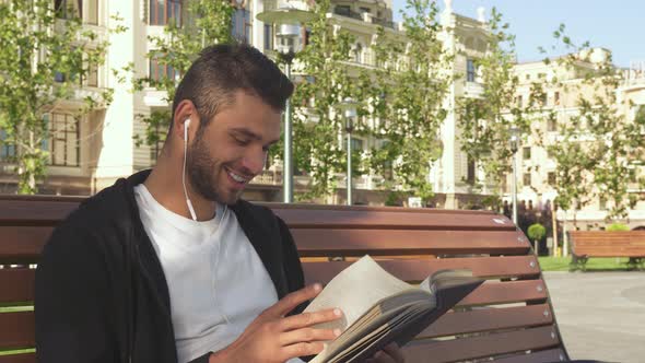 A Happy Guy Is Reading a Book in a City Alley