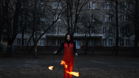 Front View of a Professional Fire Juggler Girl Performing at Night