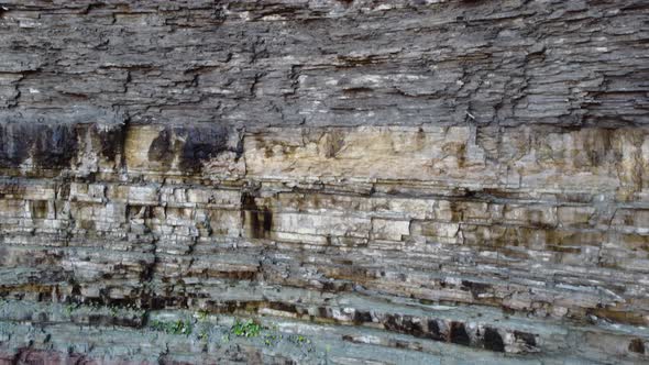 geological rock strata, colored stratified rock layers in the escarpment. descending aerial view